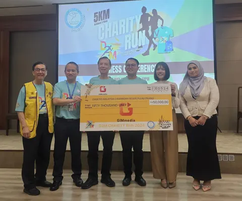 Sekumpulan peserta bergambar dengan papan penyampaian di acara larian amal.