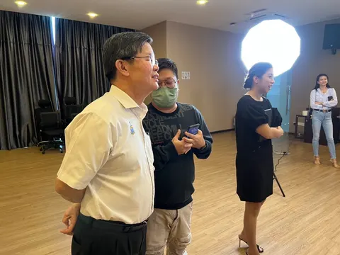 Pelawat dan pasukan produksi berkumpul di studio dengan peralatan penggambaran.