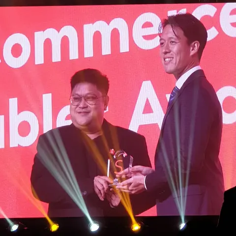 Foto arkib dengan trofi, plak atau barang penyampaian yang kelihatan.