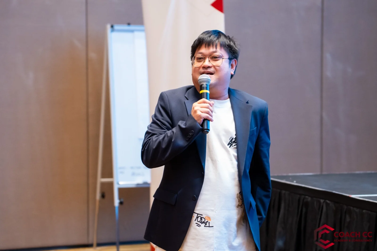 Mike bercakap menggunakan mikrofon di pentas acara.