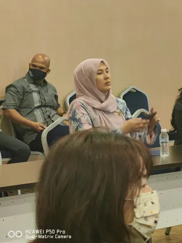Para peserta duduk mengelilingi meja semasa perbincangan bersemuka.