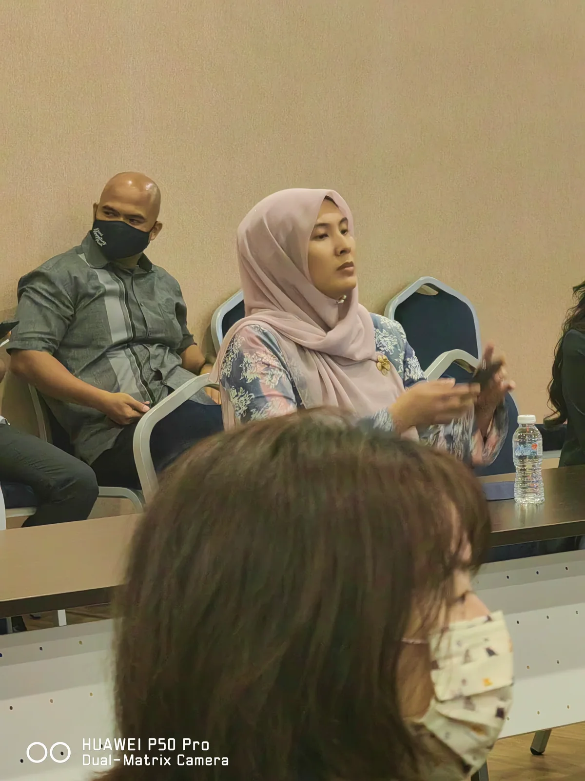 Para peserta duduk mengelilingi meja semasa perbincangan bersemuka.