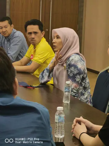 Para peserta duduk mengelilingi meja semasa perbincangan bersemuka.