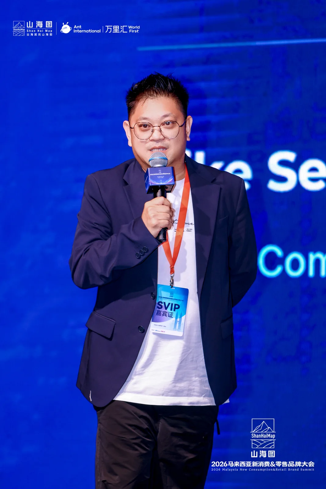 Mike bercakap menggunakan mikrofon di pentas acara.