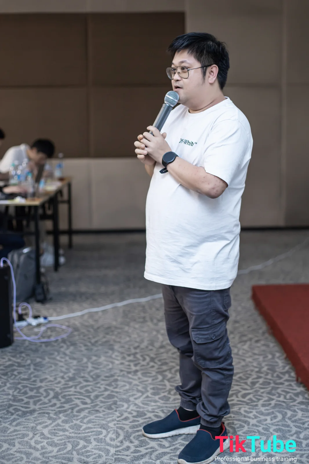 Mike Seah memegang mikrofon di bengkel